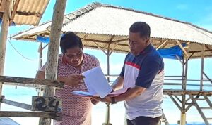 Sekda Bintan Ronny Kartika menyerahkan dokumen jabatan ASN ke Bupati Bintan Roby Kurniawan di Pantai Trikora. (Foto Hasura)