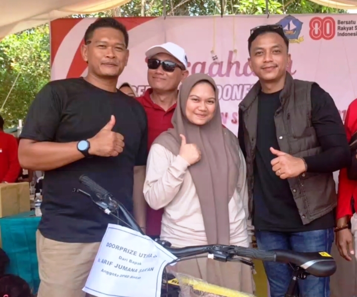 Lurah Seilekop Raja Risnanda Putra bersama Kasi Sosial Seilekop Yan menyerahkan salah satu hadiah door prize ke peserta Jalan Santai Hari Jadi Kelurahan Seilekop ke 21 dan HUT Kemerdekaan RI Ke 80. (Foto:Hasura)