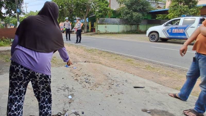 Pedagang Pecel Bawean Febriyati baju ungu hijab hitam menunjukan lokasi mobil yang menabrak dan menyeret korban. (Foto Hasura)