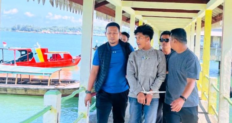 Anggota Polisi saat membawa terduga pelaku F alias B (19) yang diduga mencabuli pelajar SMP di Bintan selama tiga hari. (Foto:Hasura)