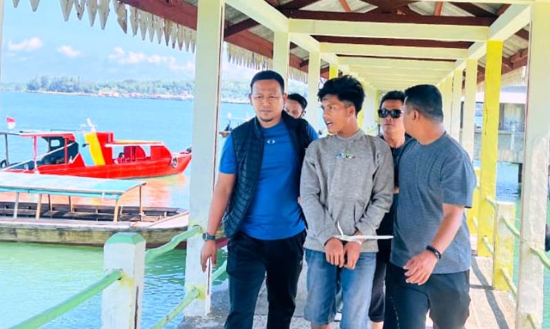 Anggota Polisi saat membawa terduga pelaku F alias B (19) yang diduga mencabuli pelajar SMP di Bintan selama tiga hari. (Foto:Hasura)