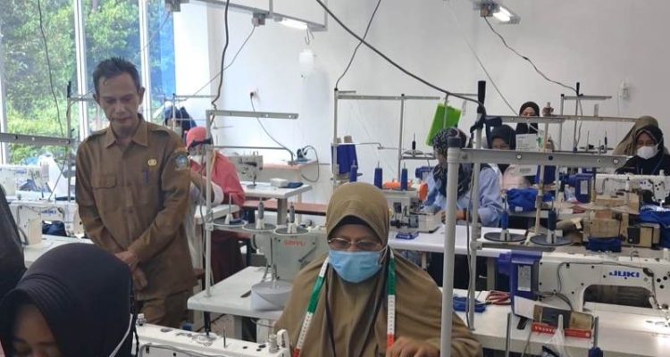 Kepala DKUPP Bintan Asysukri sedang meninjau para IKM menjahit seragam PT BIIE Lobam.(Foto Hasura)